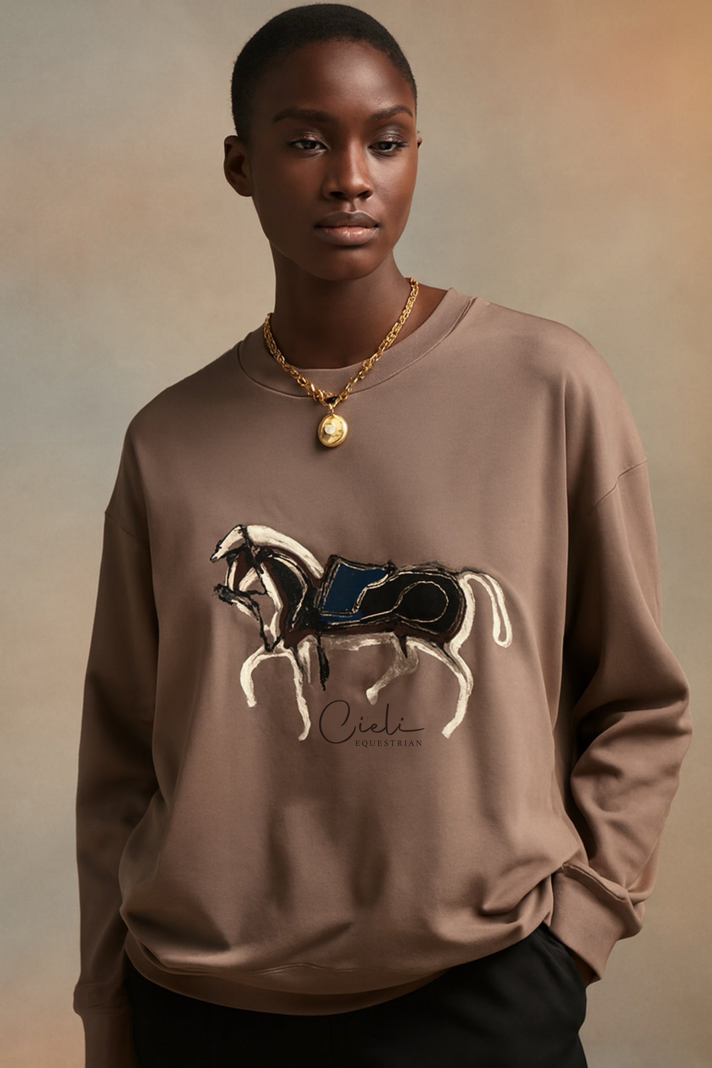 Person wearing a brown sweatshirt with a horse graphic and 'Cieli' branding on a beige background