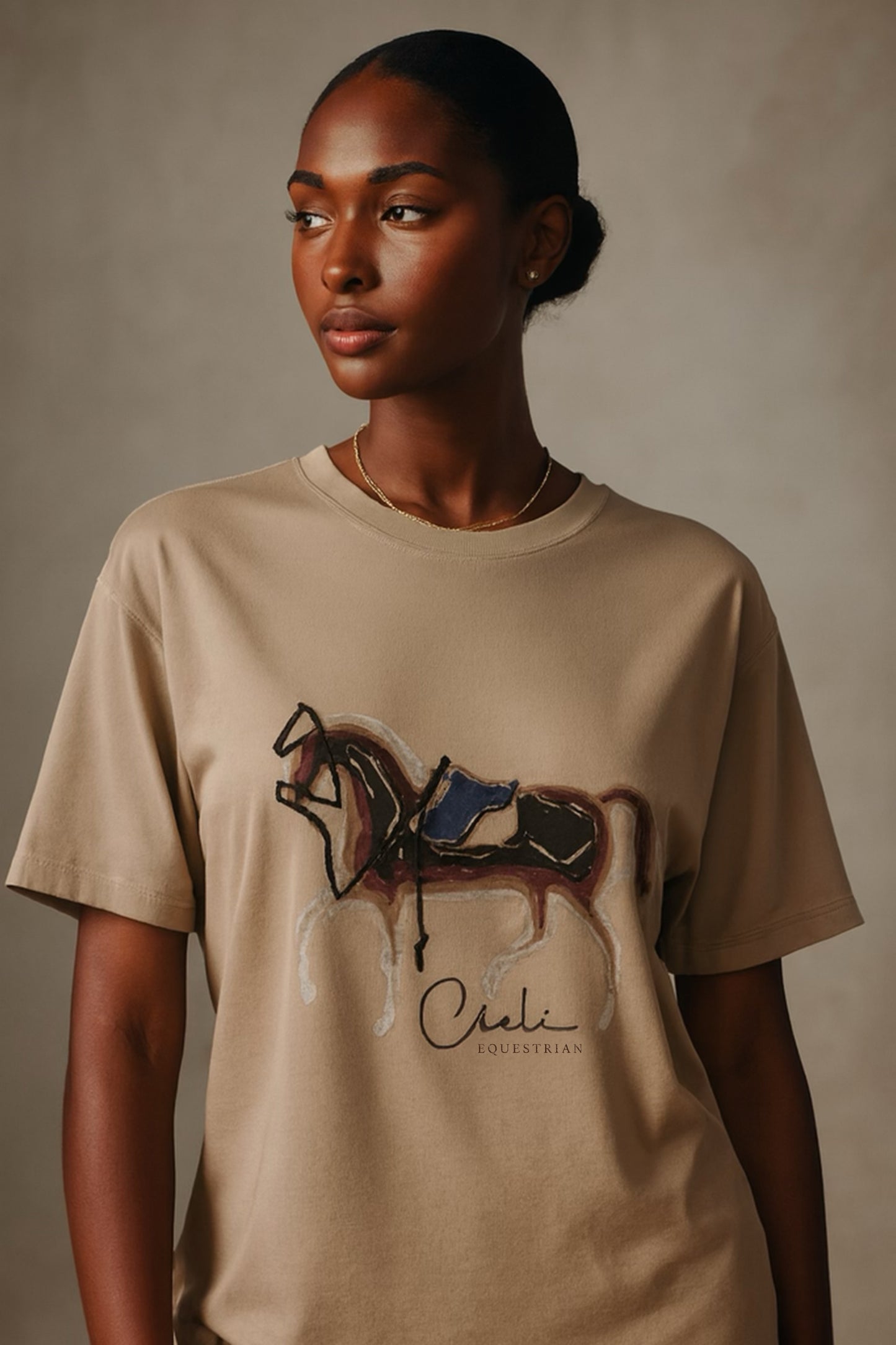 Woman wearing a beige t-shirt with a horse and saddle graphic and 'Cieli' branding.