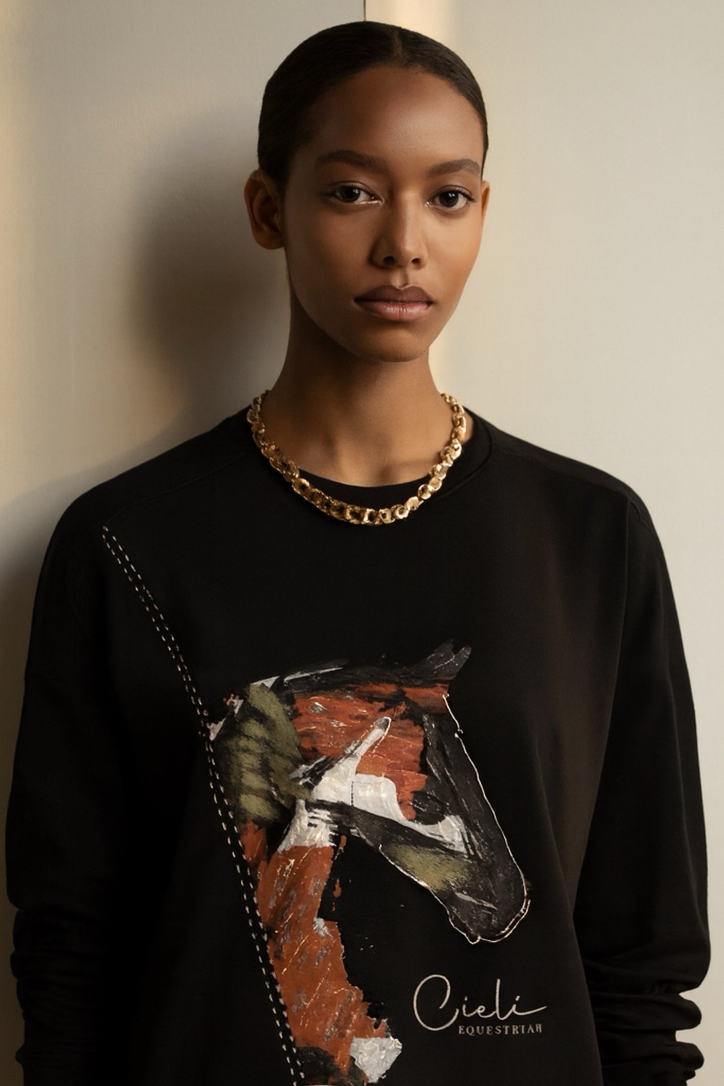 Model wearing a black sweatshirt with a horse graphic and 'Cieli' branding.