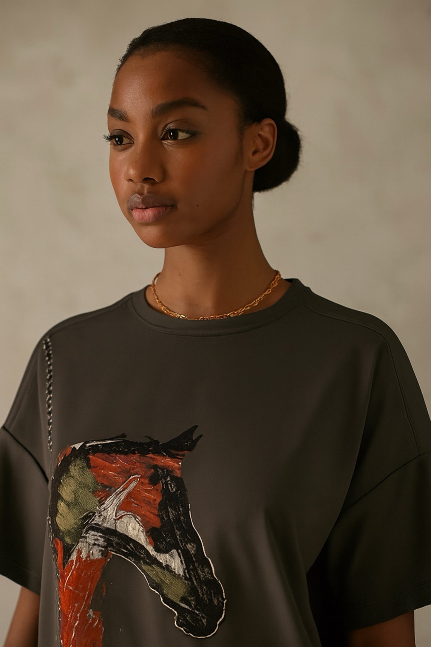 Person wearing a green t-shirt with a horse graphic on a plain background