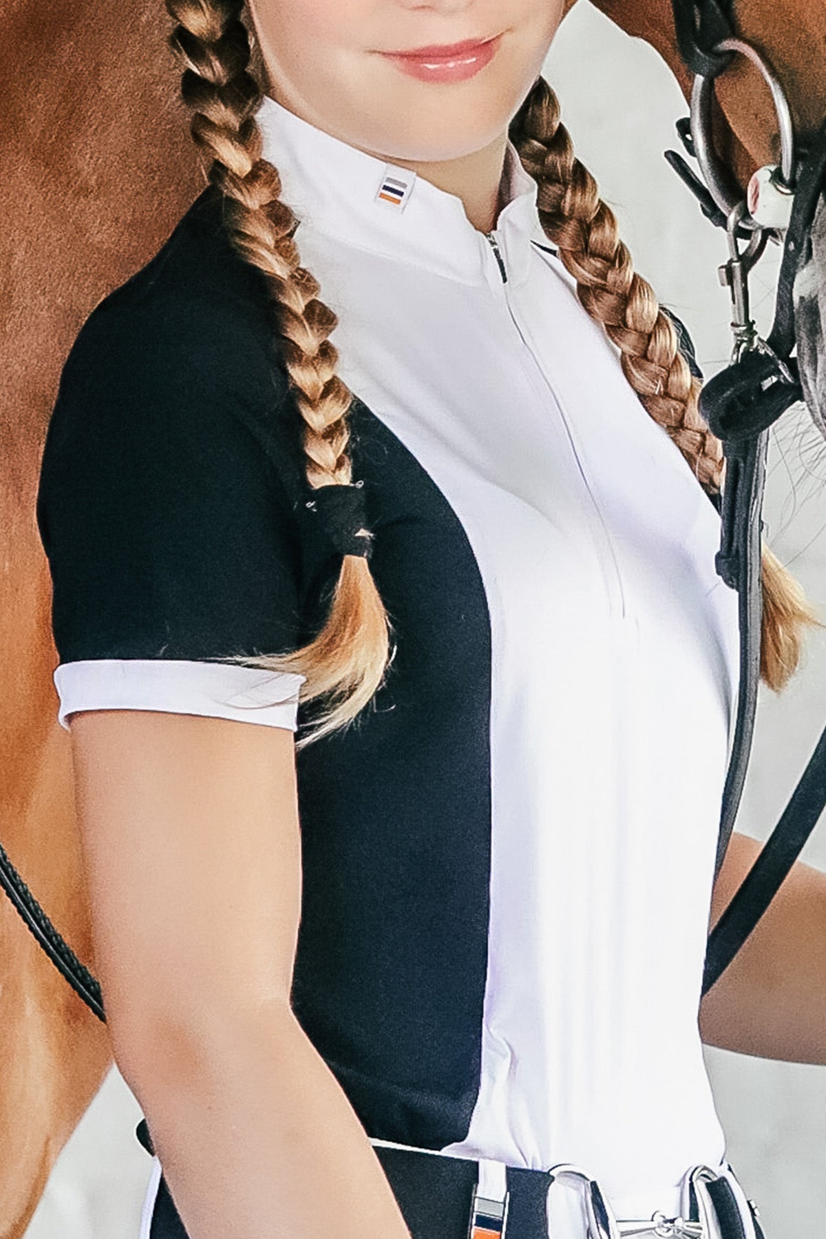 A person wearing a short sleeve show shirt in white with black accents, featuring a zipper at the neck and pleats at the back.