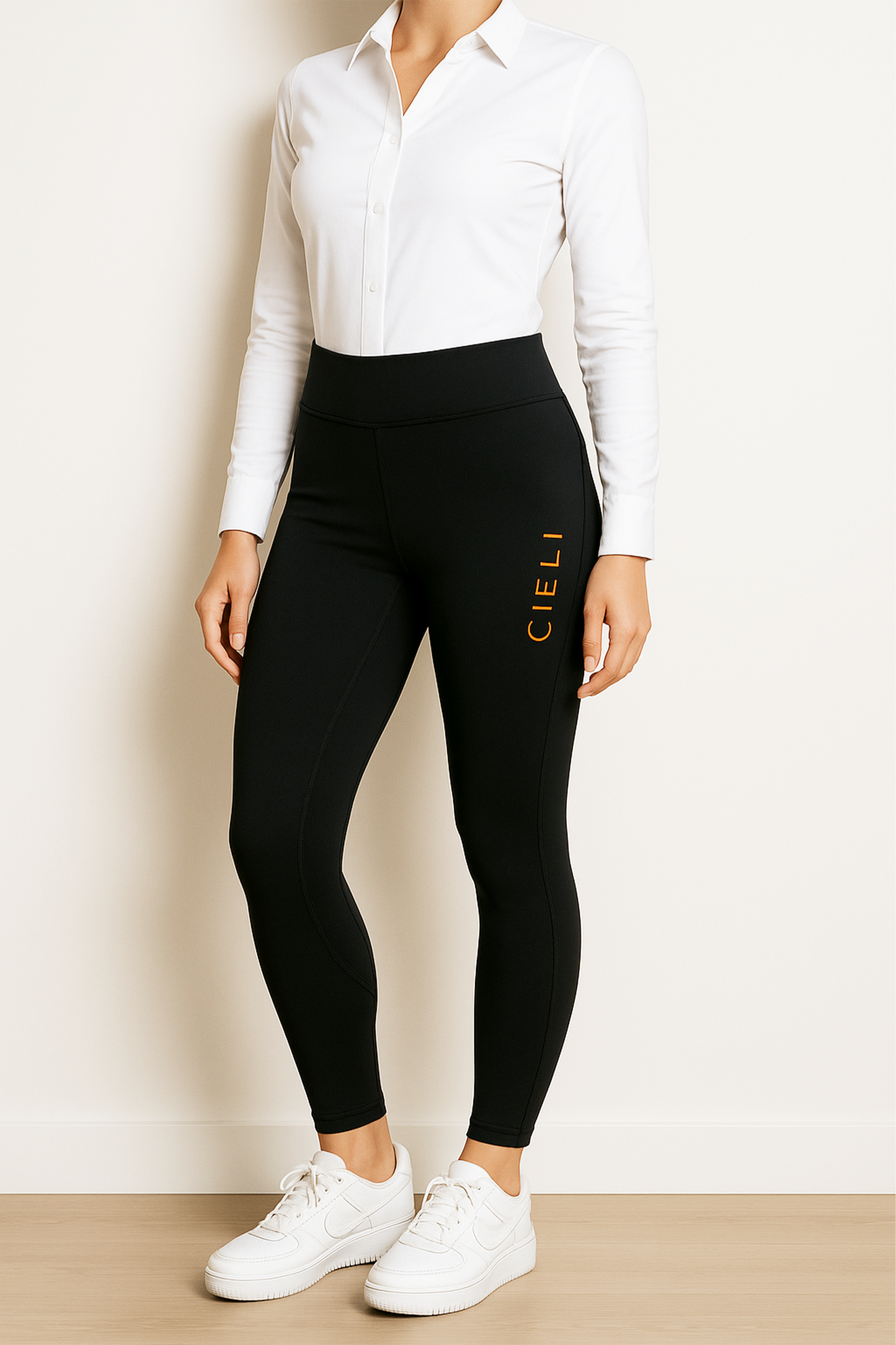 Person wearing black leggings with 'CIELI' branding and a white shirt against a beige background