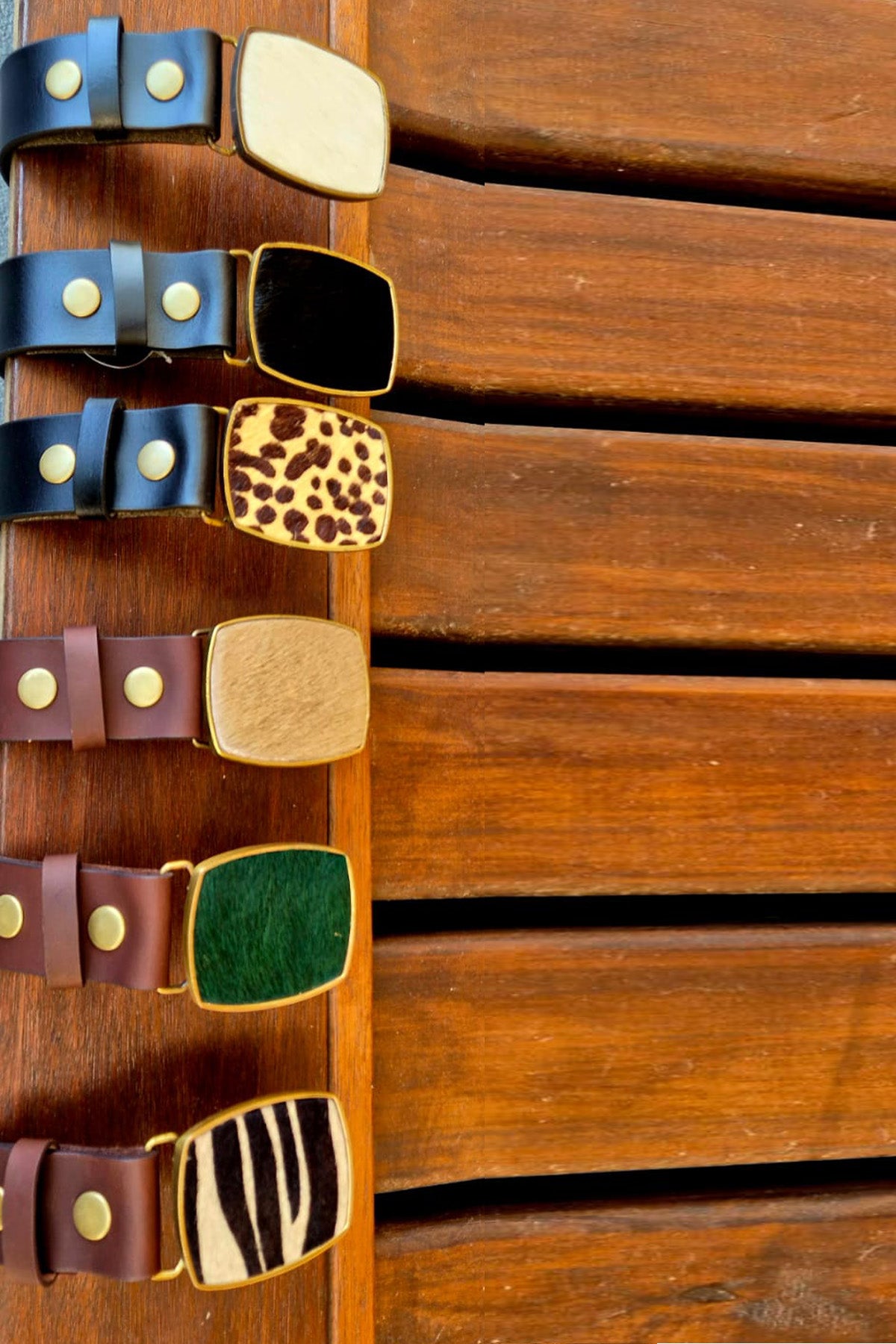 Collection of colourful leather belts on a wooden board