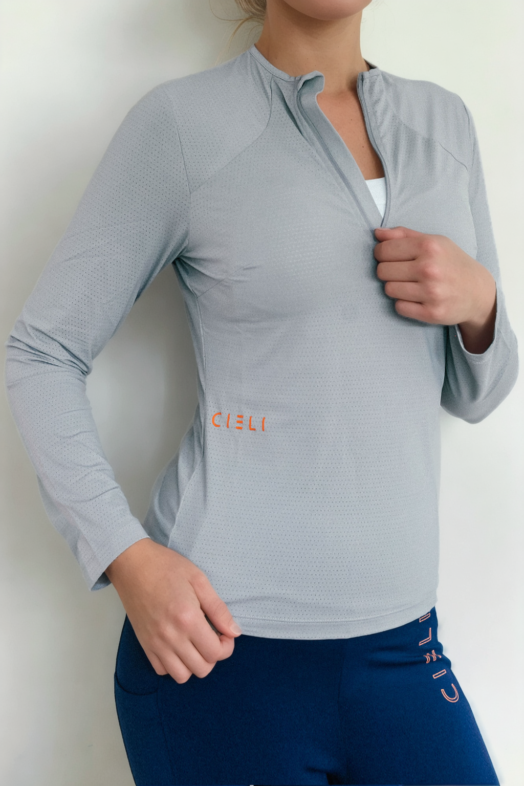 A lady wearing a Cieli Equestrian sun protective grey equestrian riding shirt ideal for horse safari.