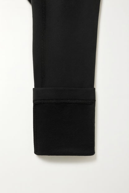 Close-up of a black pants folded up with a white background