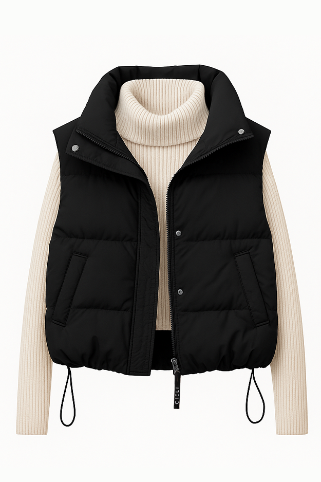 Black puffer vest over a cream ribbed sweater on a white background