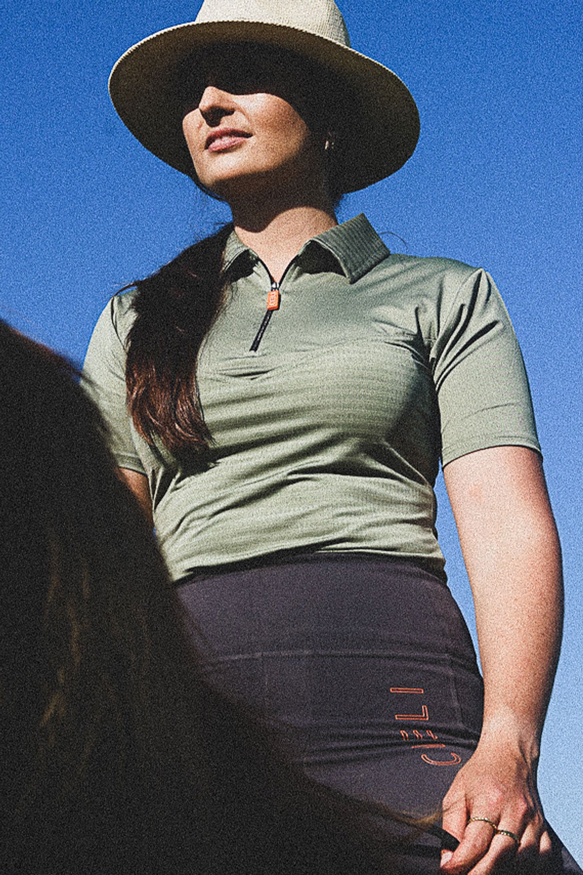 Lady wearing a Cieli Equestrian sports polo tech shirt in green that is sun protective and ideal for African horse safaris.