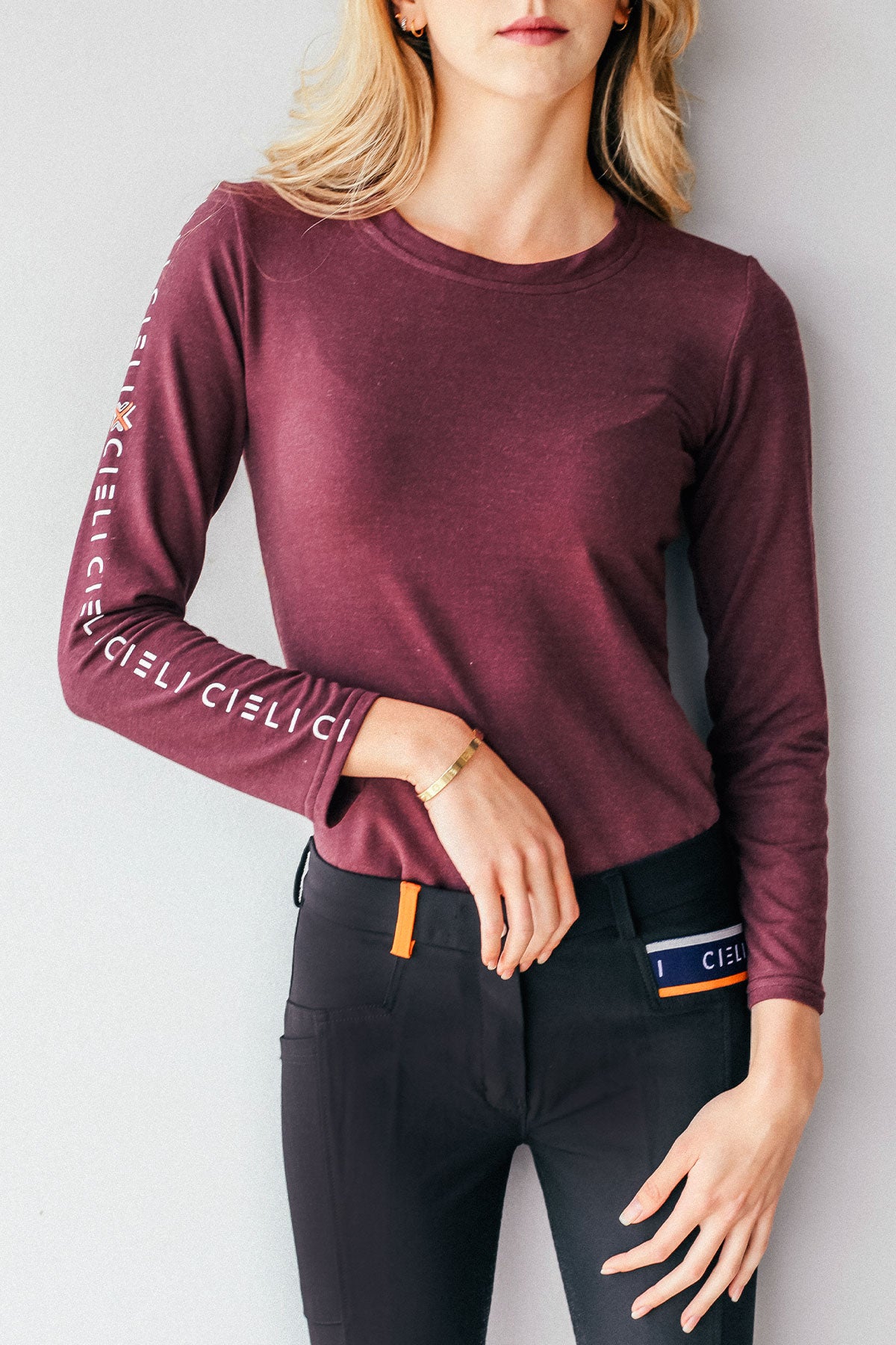 Lady wearing a Cieli Equestrian long sleeve horse riding shirt in maroon with ultra soft fabric.