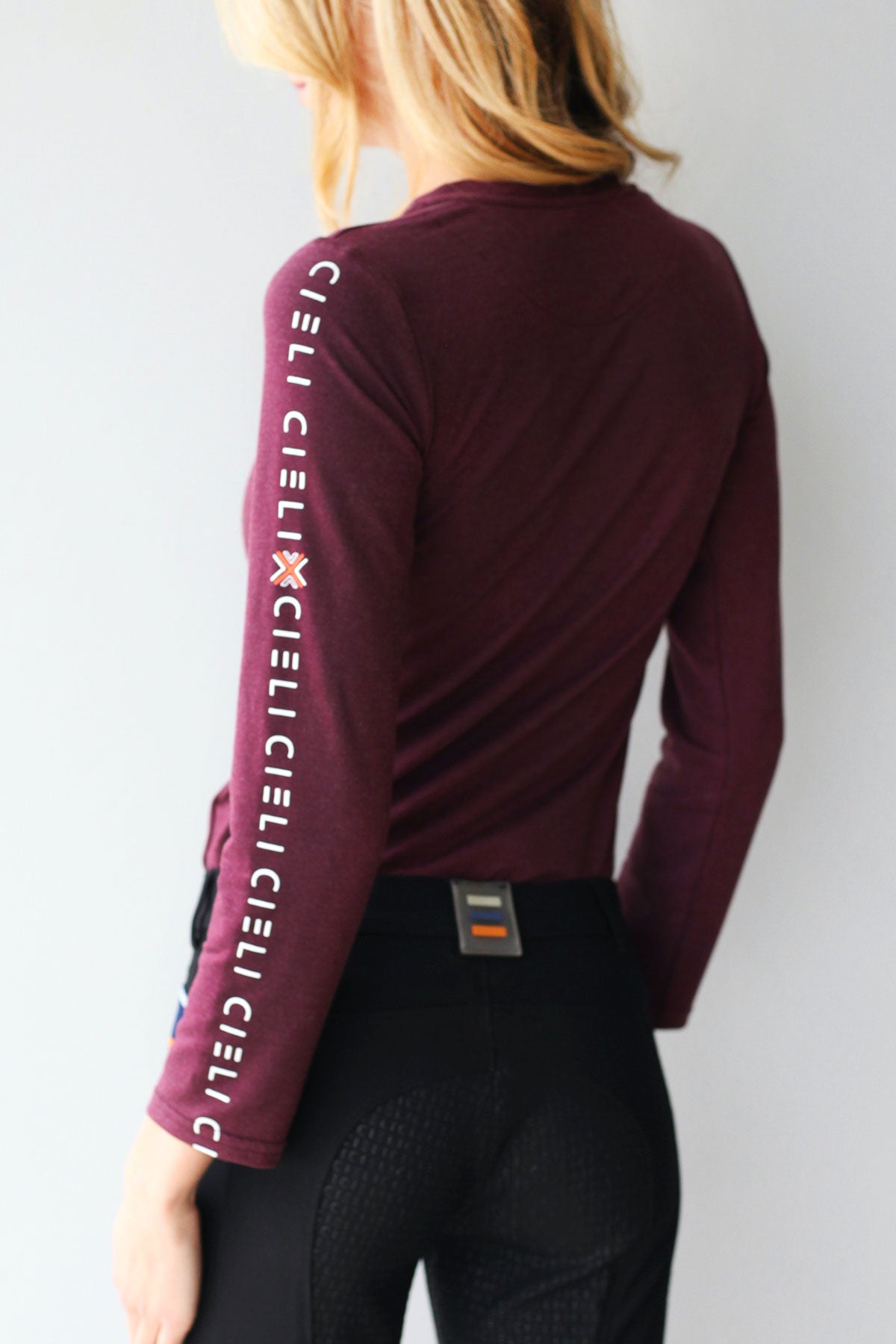 Lady wearing a Cieli Equestrian long sleeve horse riding shirt in maroon with ultra soft fabric.