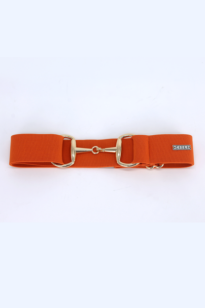 lady wearing a Cieli Equestrian elastic snaffle bit belt in orange with a gold buckle that is one size fits all