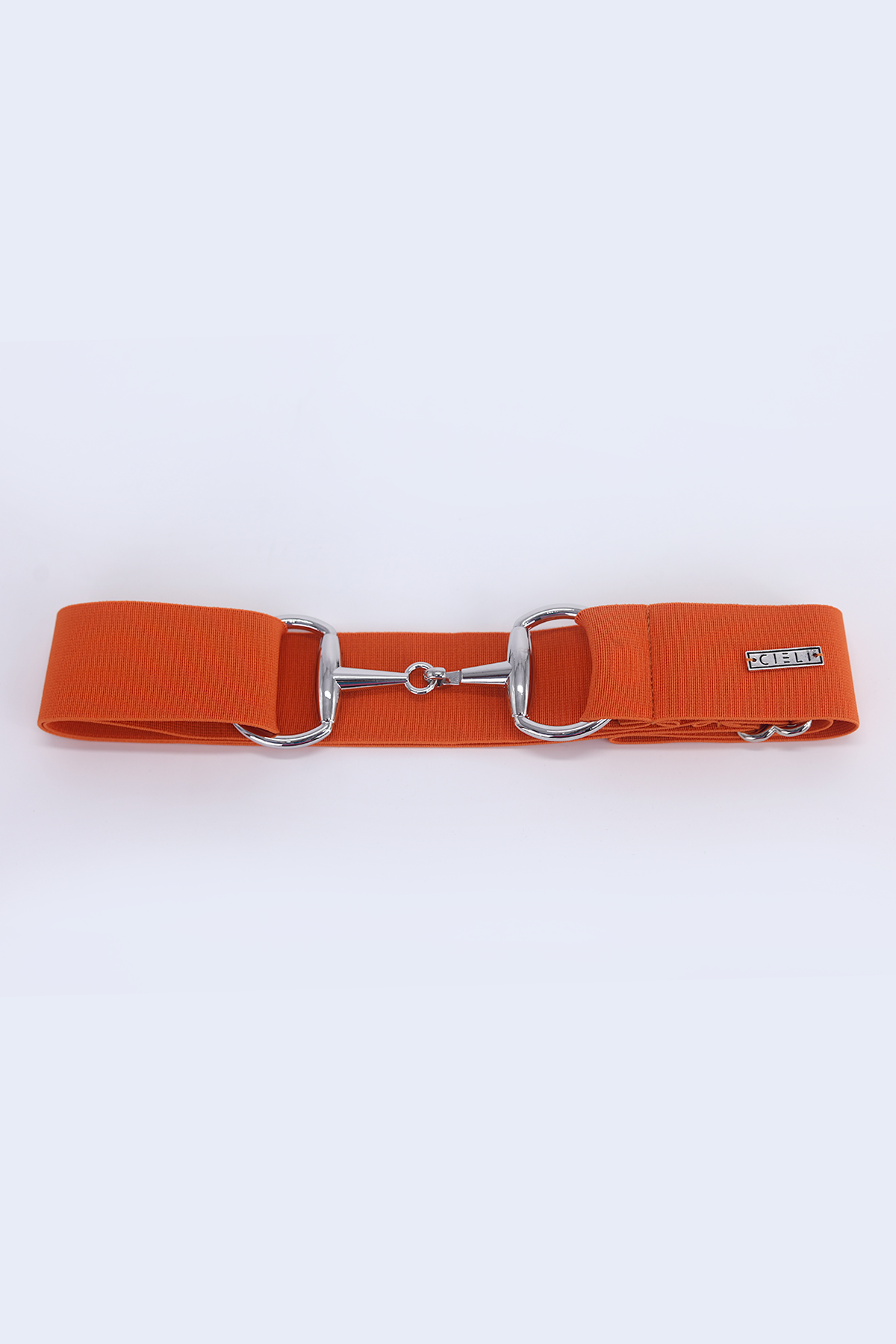 lady wearing a Cieli Equestrian elastic snaffle bit belt in orange with a silver buckle that is one size fits all