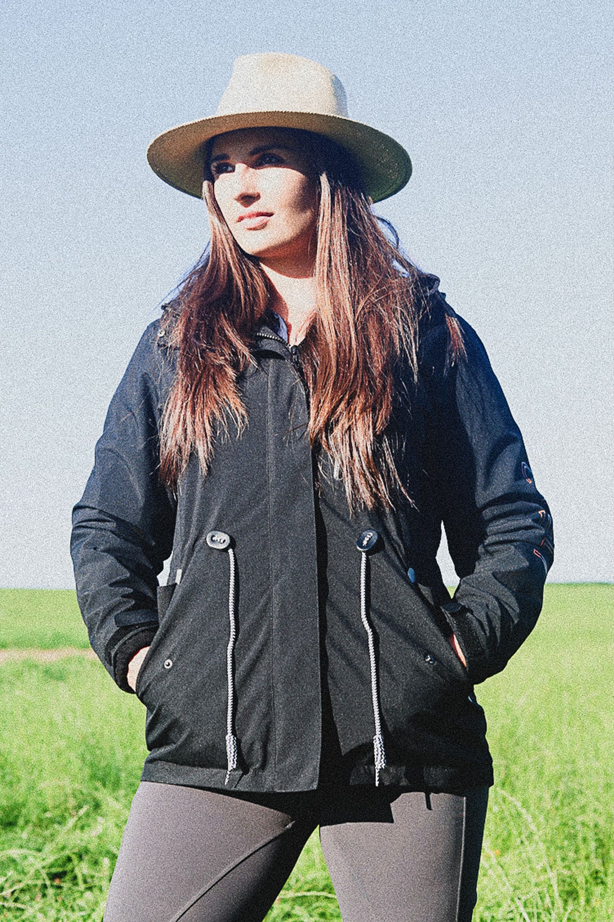 Lady wearing a Cieli Equestrian black 2 in 1 waterproof jacket with hood ideal for African horse safari