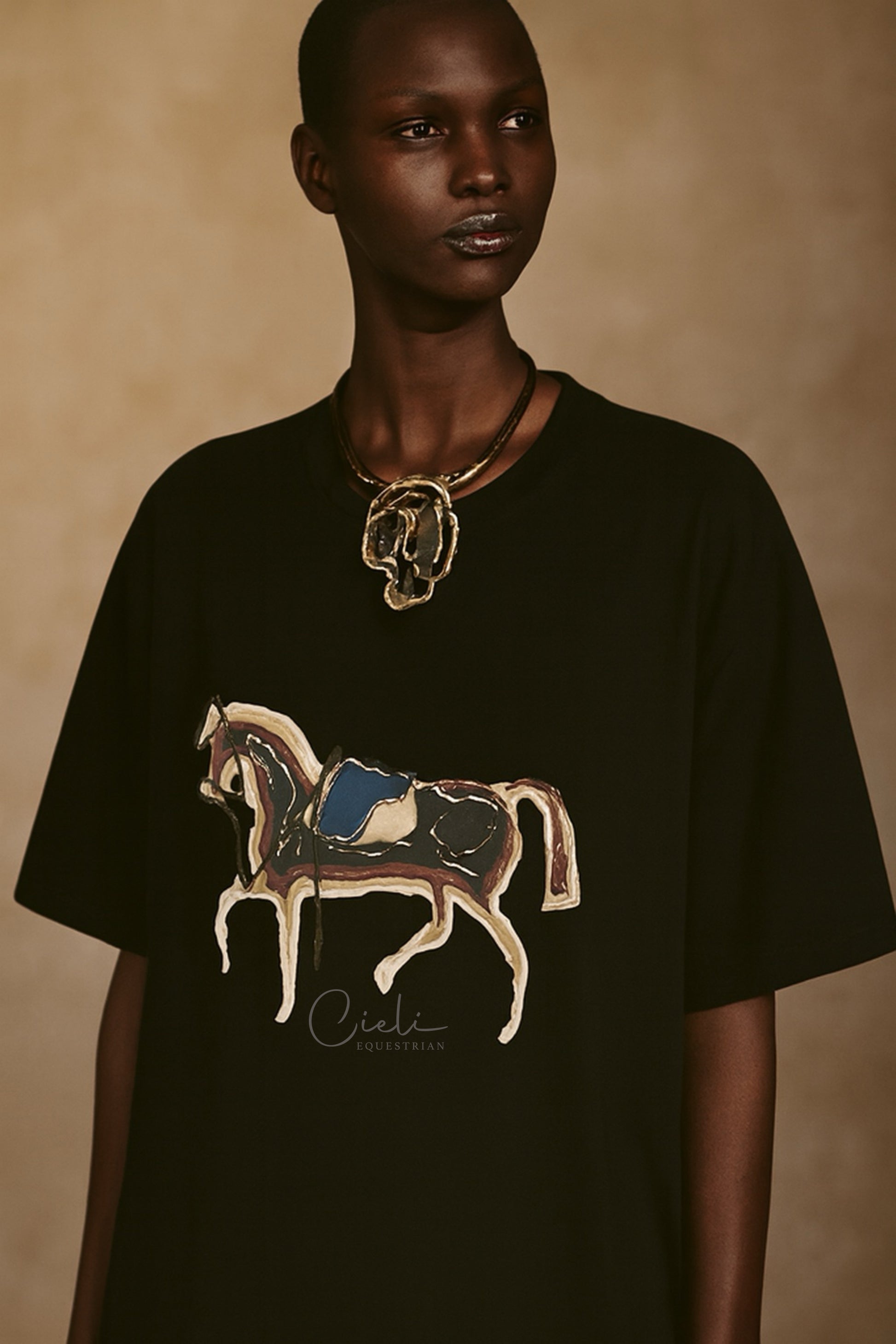 Person wearing a black t-shirt with a horse design on a beige background