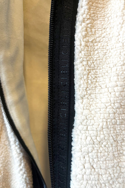 Close-up of a textured fabric with a zipper and visible branding.