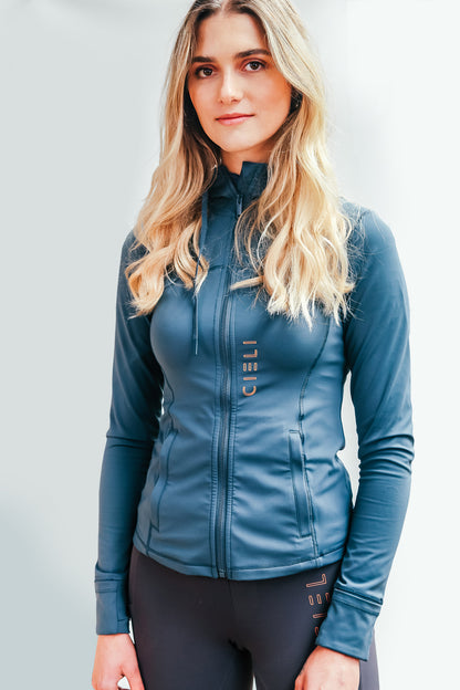 Lady wearing a Cieli Equestrian blue jacket with hood, ideal for riding and African horse safaris.