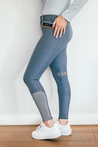 Lady wearing everyday grey equestrian pants, resembling a sporty twist on modern riding breeches.