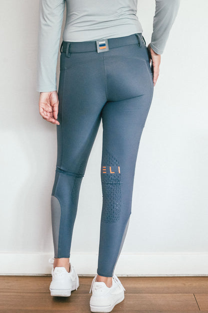 Lady wearing everyday grey equestrian pants, resembling a sporty twist on modern riding breeches.