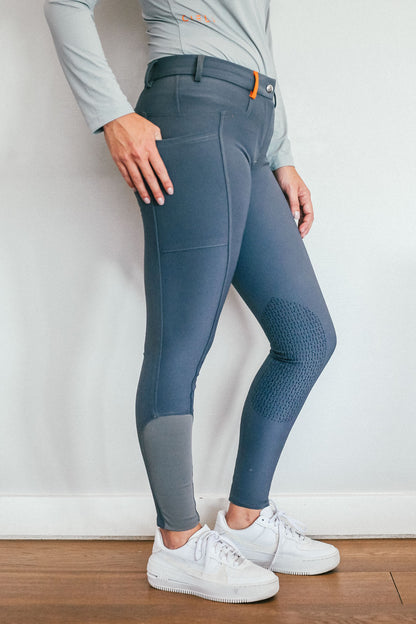 Lady wearing everyday grey equestrian pants, resembling a sporty twist on modern riding breeches.