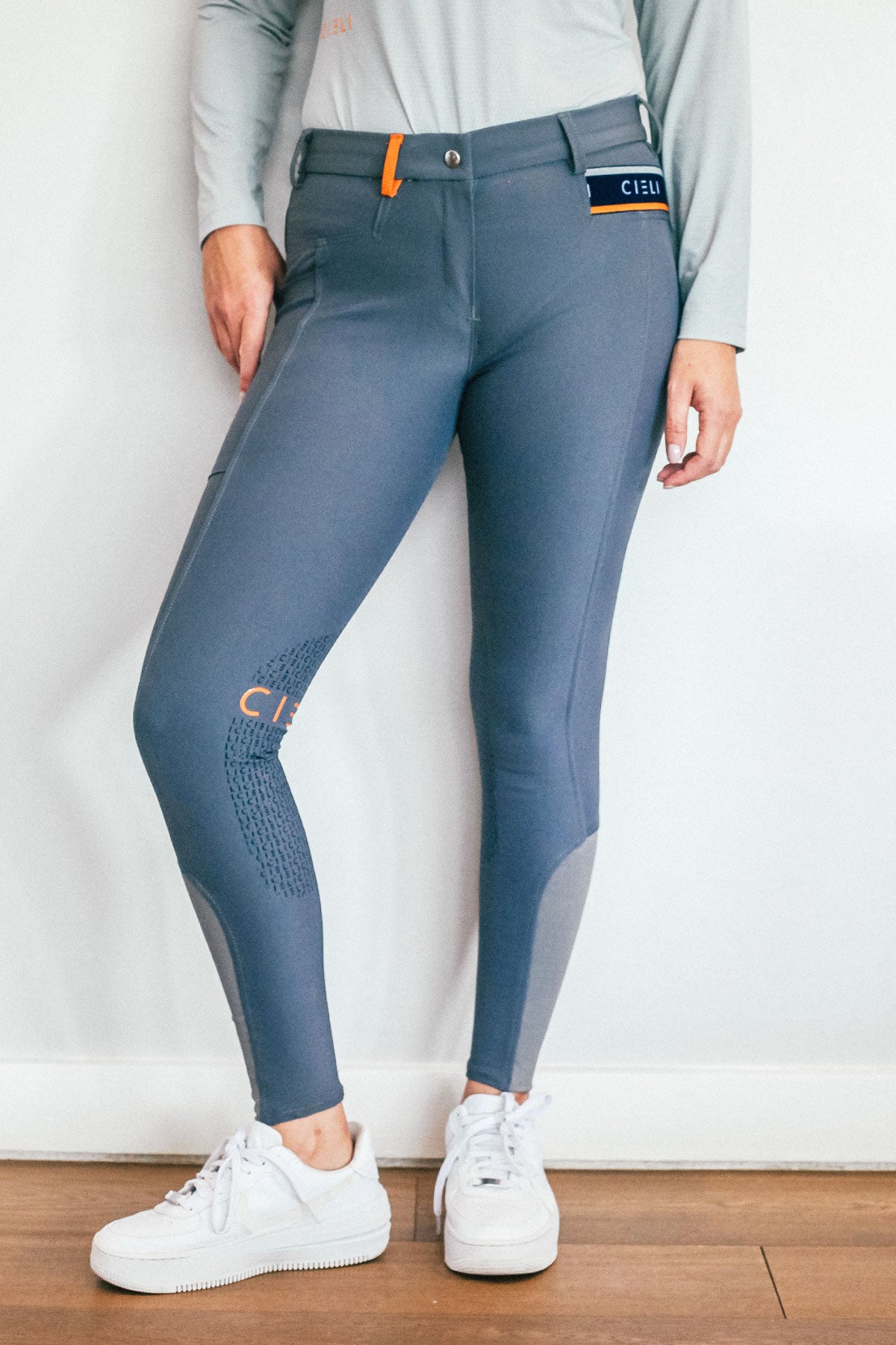 Lady wearing everyday grey equestrian pants, resembling a sporty twist on modern riding breeches.