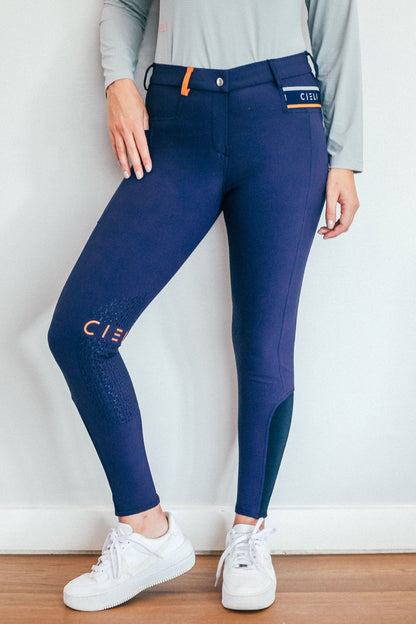 Lady wearing everyday navy equestrian pants, resembling a sporty twist on modern riding breeches.