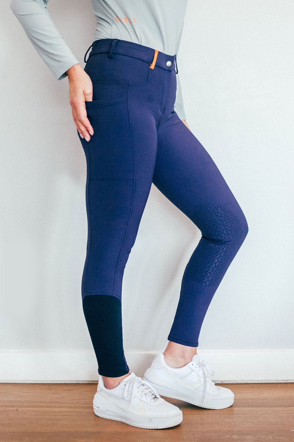 Lady wearing everyday navy equestrian pants, resembling a sporty twist on modern riding breeches.