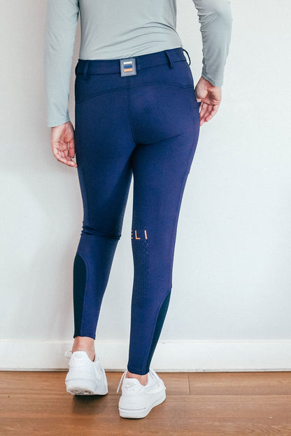 Lady wearing everyday navy equestrian pants, resembling a sporty twist on modern riding breeches.