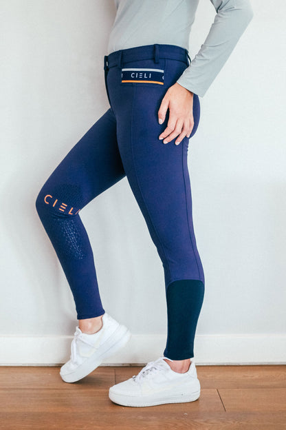 Lady wearing everyday navy equestrian pants, resembling a sporty twist on modern riding breeches.