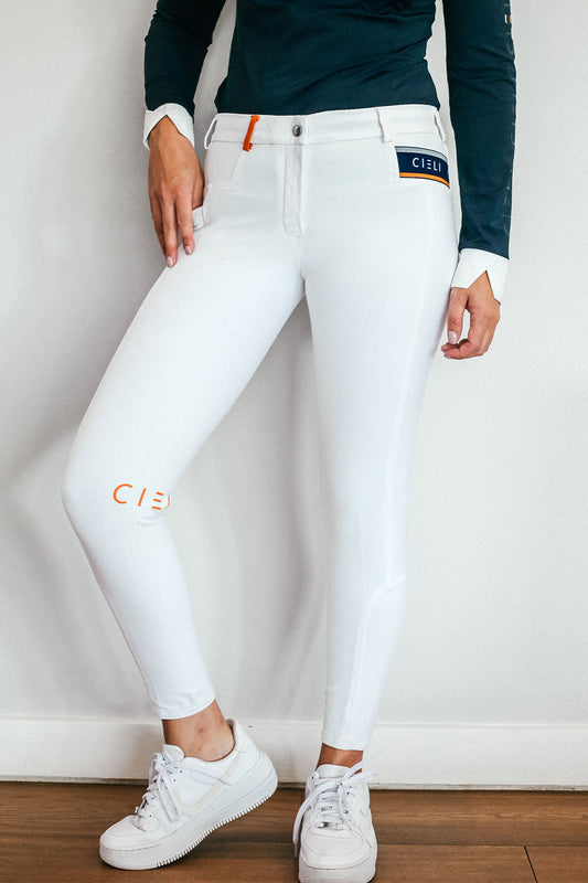 Lady wearing show performance white equestrian pants, resembling a sporty twist on modern riding breeches.