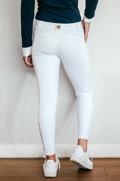 Lady wearing show performance white equestrian pants, resembling a sporty twist on modern riding breeches.